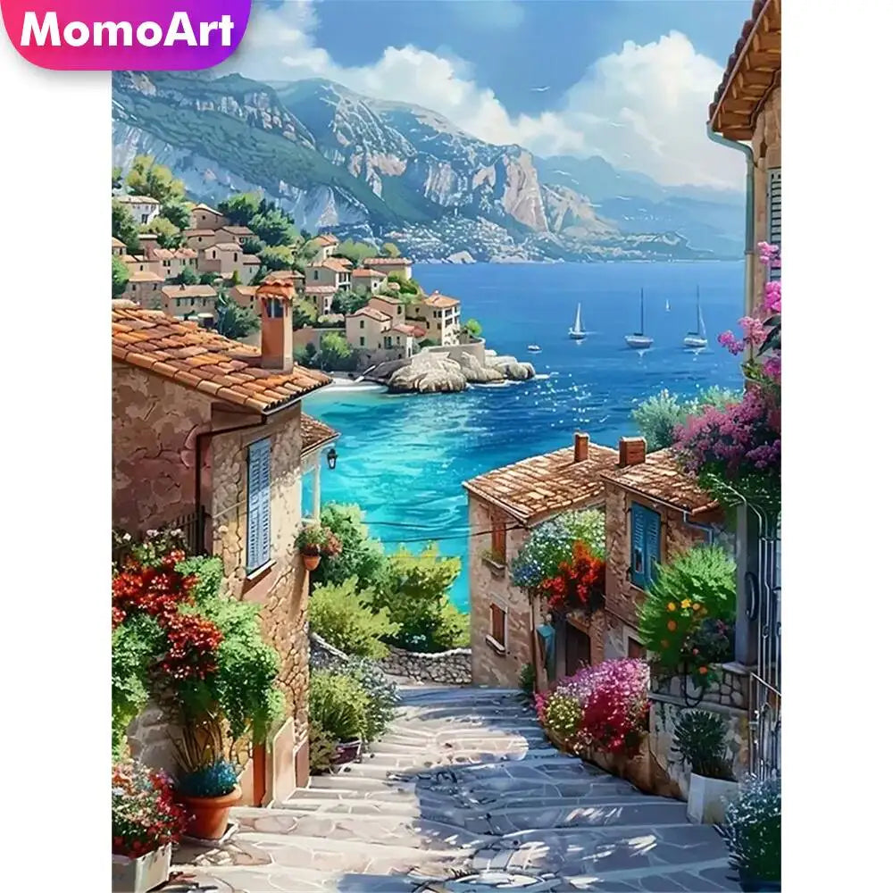 Broderie diamant d'une ruelle en escalier bordée de maisons fleuries, qui descend vers une baie turquoise