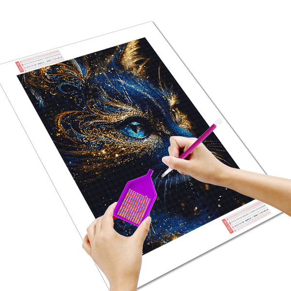 Une main pose des diamants avec un stylo sur la toile d'un chat