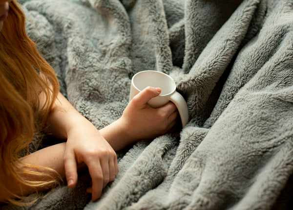 am-tasse-plaid : une tasse tenue dans un plaid moelleux