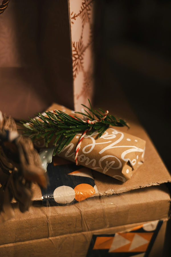 am-cadeaux-kraft : petits cadeaux emballés dans du papier kraft avec une branche de sapin